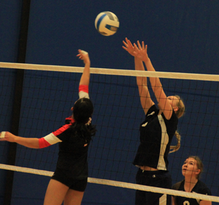 Ally Hale goes up for a block against Deary as Rachael Frei watches.