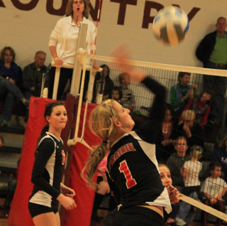 Leah Holthaus spikes the ball at Kamiah as Kyndahl Ulmer watches.