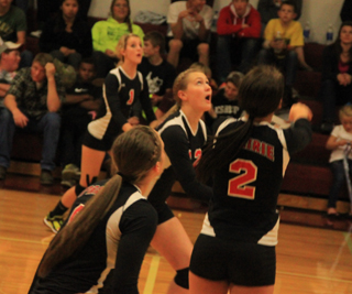 Leah Holthaus, background, Kayla Schumacher and Hailey Danly, foreground, all watch the ball after Natasha Gimmesons set at Kamiah.