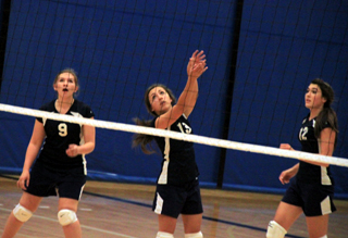 Rachel Waters puts the ball over the net as Rachael Frei and Megan Seubert watch in Summits District match against Deary.