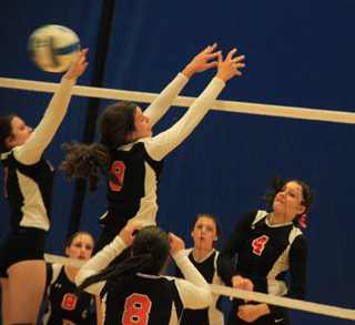 Shayla VonBargen pounds the ball past Troy’s blockers at District. Hailey Danly, 8, and Natasha Gimmeson watch.