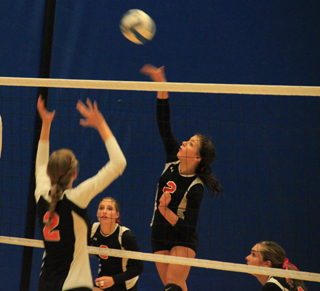 Natasha Gimmeson goes for the kill against Troy as Hailey Danly, left, and Krystin Uhlenkott, right, watch.