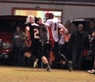 Jake Bruner tries to ward off the Troy defender as he gains yardage down the sideline on a running play.