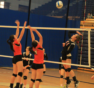Krystin Uhlenkott winds up for a spike against Troy. Kayla Schumacher can be seen between the Troy blockers.