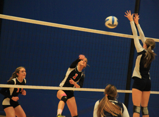Leah Holthaus pounds the ball past a Lapwai blocker. At left is Krystin Uhlenkott.