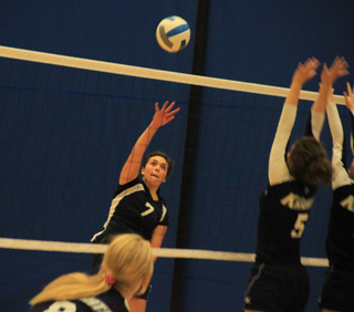 Megan Rehder hits the ball away from the Logos blockers at their district match last Wednesday.