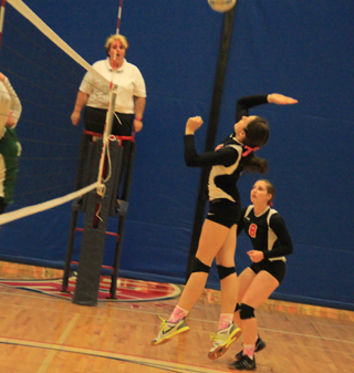 Shayla VonBargen goes up for a spike against Potlatch as Hailey Danly watches.