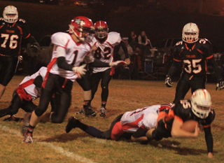 Tyler Hankerson tackles Troys Cody Self. Also shown are Lucas Arnzen, Isaiah Shears (on the ground) and Casey Danly.