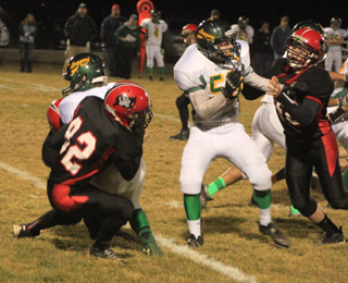 Casey Danly pulls down a Potlatch runner behind the line of scrimmage for a loss. At right is Matt Schwartz.