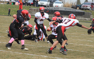 Hunter McWilliams cuts back to the right as Dakota Wilson blocks the defender at the left to clear a path and Tyler Hankerson wards off the defender to the right. McWilliams wound up breaking free for a 48 yard touchdown run. In the background is Rhett Schlader with Jake Bruner on the ground behind Schlader.