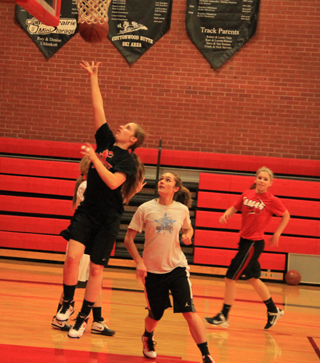 Hailey Danly scores a layup during a full court conditioning and lay-up drill. Also shown are Krystin Uhlenkott and Chaye Uptmor.
