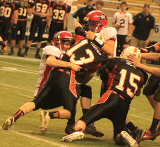 Lucas Arnzen, left, and Matt Schwartz tackle Troys Kellen Hoskins for a loss.