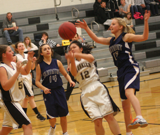 Summits Rachel Waters, 14, and Ashlee Stubbers, 12, play defense against Highland. Photo by Steve Wherry.