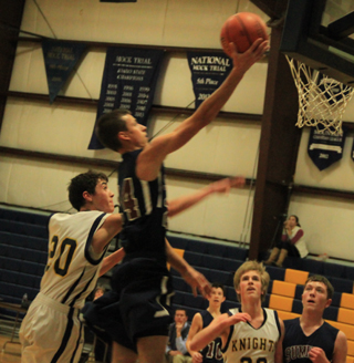 Michael Waters swoops in for 2 of his 26 points at Logos. At right is Patrick Chmelik while Tyler Krogh can be seen in the background.