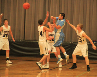 Summit defenders block the way to the hoop forcing a pass. From left are Michael Waters, Patrick Chmelik and Nathan Beckman.