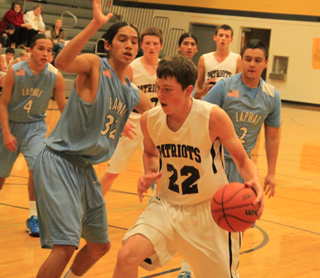 Patrick Chmelik has the ball in the low post against Lapwai. Also shown are Josh Lustig and Michael Waters.
