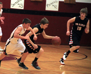 Bryson Higgins takes the ball upcourt after a Kamiah turnover. At right is Tanner Ross.