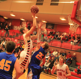 Lucas Arnzen goes high for a shot against Nezperce. At right is Tanner Ross.