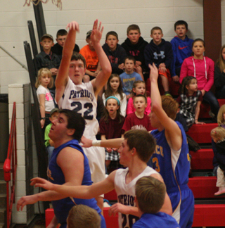 Patrick Chmelik shoots from the baseline against Nezperce. Also shown is Josh Lustig.