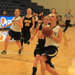 Sarah Chmelik leads a break in the Highland game and is about to score a lay-up. Also shown are Rachael Frei, 2, and Megan Rehder.