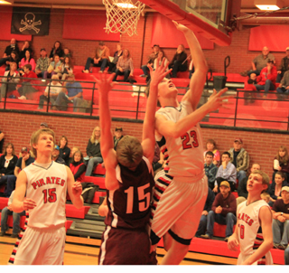 Lucas Arnzen scores a lay-up against Kamiah. At right is Jared Higgins and at left is Tanner Ross.