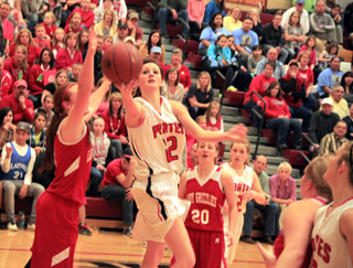 Kyndahl Ulmer goes for the scoop lay-up against Grace. At right is Leah Holthaus and in the background is Nicole Wemhoff.