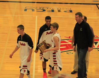Seniors Dylon Bruegeman, Tyler Hankerson and Jared Higgins were presented the league championship trophy prior to Mondays game. They were anxious to get to the task at hand of beating Genesee and earning a trip to State.