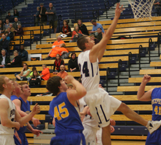 Michael Waters puts up a shot against Nezperce at District. At left is Nathan Beckman.