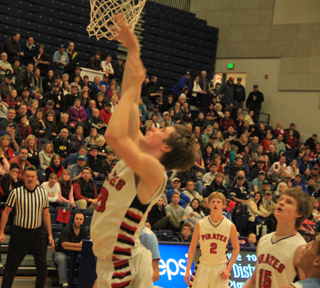 Lucas Arnzen scores a lay-up as Rhett Schlader and Tanner Ross watch.