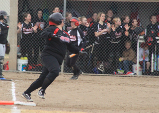 Marina Evans heads for second with a double as the players in the Prairie dugout watch the flight of the ball into the outfield.