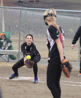 Hanna Ross is about to catch the ball for an out at first against Troy after pitcher Leah Holthaus, foreground, had fielded a comebacker.