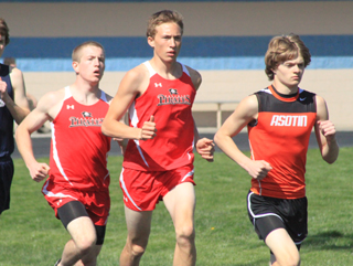 Drew Cochran, left, and Peter Spencer on the first lap of the 3200. Spencer would stay on the shoulder of the Asotin runner at right until midway through the final lap.