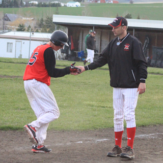 Clark Bruno is congratulated by coach Kyle Westhoff as he rounds third on his 2-run homer against Potlatch.