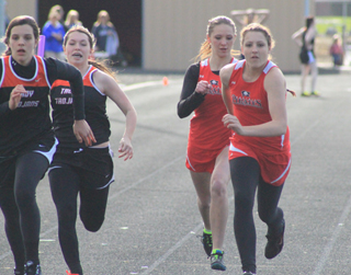 Mykaela McWilliams hands off to Shayla VonBargen as Prairie and Troy were close at this point in the 4x100 relay but Prairie went to win.