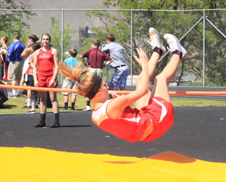 Brandi Gehring attempts to clear 4'8, just clipping the bar with her feet. In the background is Shayla Vonbargen, awaiting her attempt.