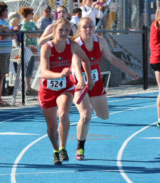 Keely Schmidt hands a lead to Mykaela McWilliams after the first leg of the 4x400 relay.