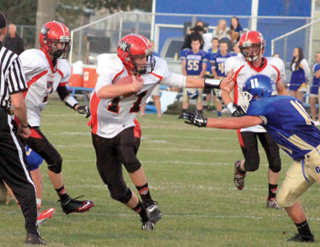 Jake Bruner wards off a Genesee defender before breaking loose for his second touchdown. Also shown are Rhett Schlader and Lucas Arnzen.