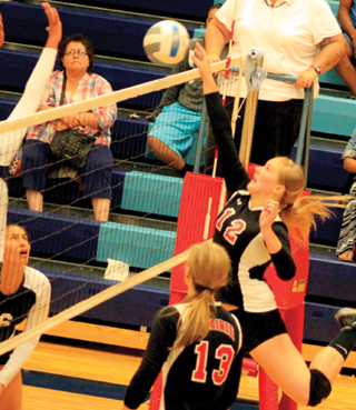 Kayla Schumacher tips the ball over against Lapwai. She had a big service run that turned the match around for Prairie. #13 is Holli Uhlorn.