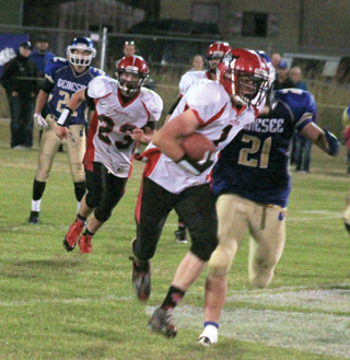 Lucas Arnzen stiffarms a Genesee defender on a running play. #23 is Calvin Hinkelman.