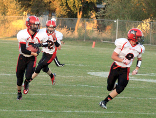 Rhett Schlader, left, gains yardage after catching a short pass. Lead blocking at right is Terran Peery while behind Schlader is Tanner Ross.