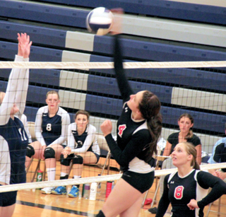 Shayla VonBargen pounds the ball at Grangeville as Hailey Danly watches after making the set.