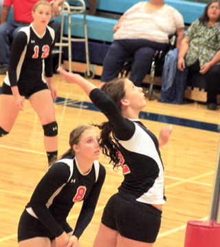 Natasha Gimmeson goes for a kill against Lapwai. Also shown are Kayla Schumacher, 12, and Hailey Danly, 8.