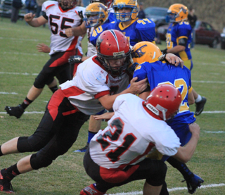 Devin Bruegman and Brandon Anderson combine on a tackle against Salmon River. #55 is Bobby Hood.