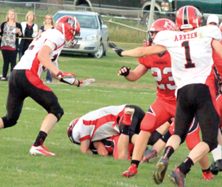 Rhett Schlader sacks the Council quarterback and also forced a fumble which Tanner Ross, left, wound up recovering. Lucas Arnzen is shown at right.