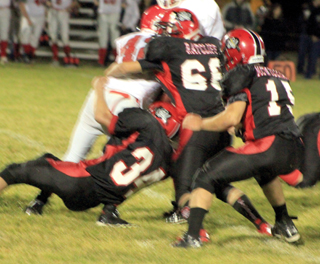 Dally Ratcliff and Jayce Huling tackls a C.V. Runner as Hunter McWilliams moves in to help.