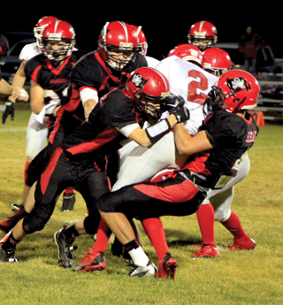 Mason Dalgliesh and Isaiah Shears make a tackle with Tanner Ross moving in from the left. Calvin Hinkelman is at far left.