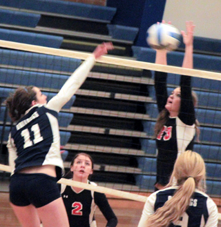 Holli Uhlorn stuffs a Grangeville spike at the Genesee Tournament. Also shown is Natasha Gimmeson.