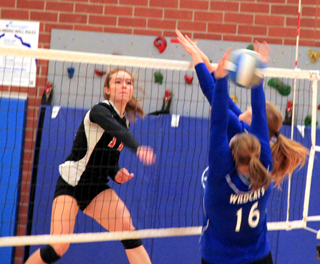 Krystin Uhlenkott pounds a spike past Colton blockers at the Genesee Tournament.