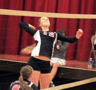 Kayla Schumacher pounds the ball over against Potlatch. In the foreground is Hailey Danly.