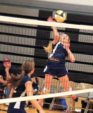 Lauren Stubbers goes for a kill against Logos. Also shown is Megan Seubert.